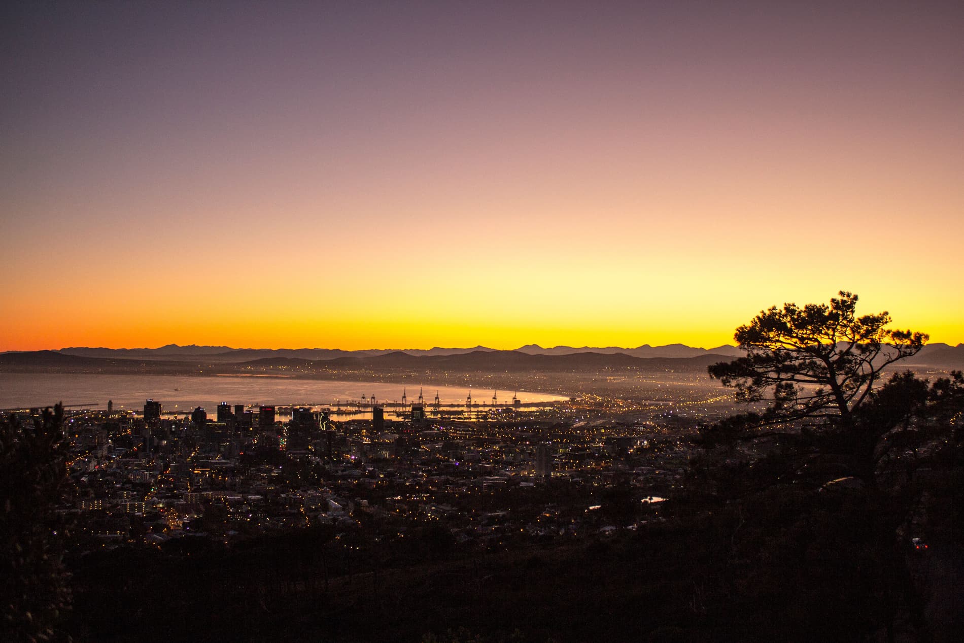 Aerial view of Cape Town's City Bowl and harbour at dusk, mountains in silhouette